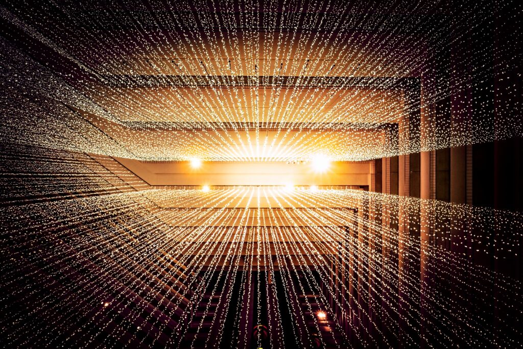 an image depicting what a data quality firewall might look like. data is streaming from a central point, with a bright light depicting the orderly transmission of data through the firewall.
